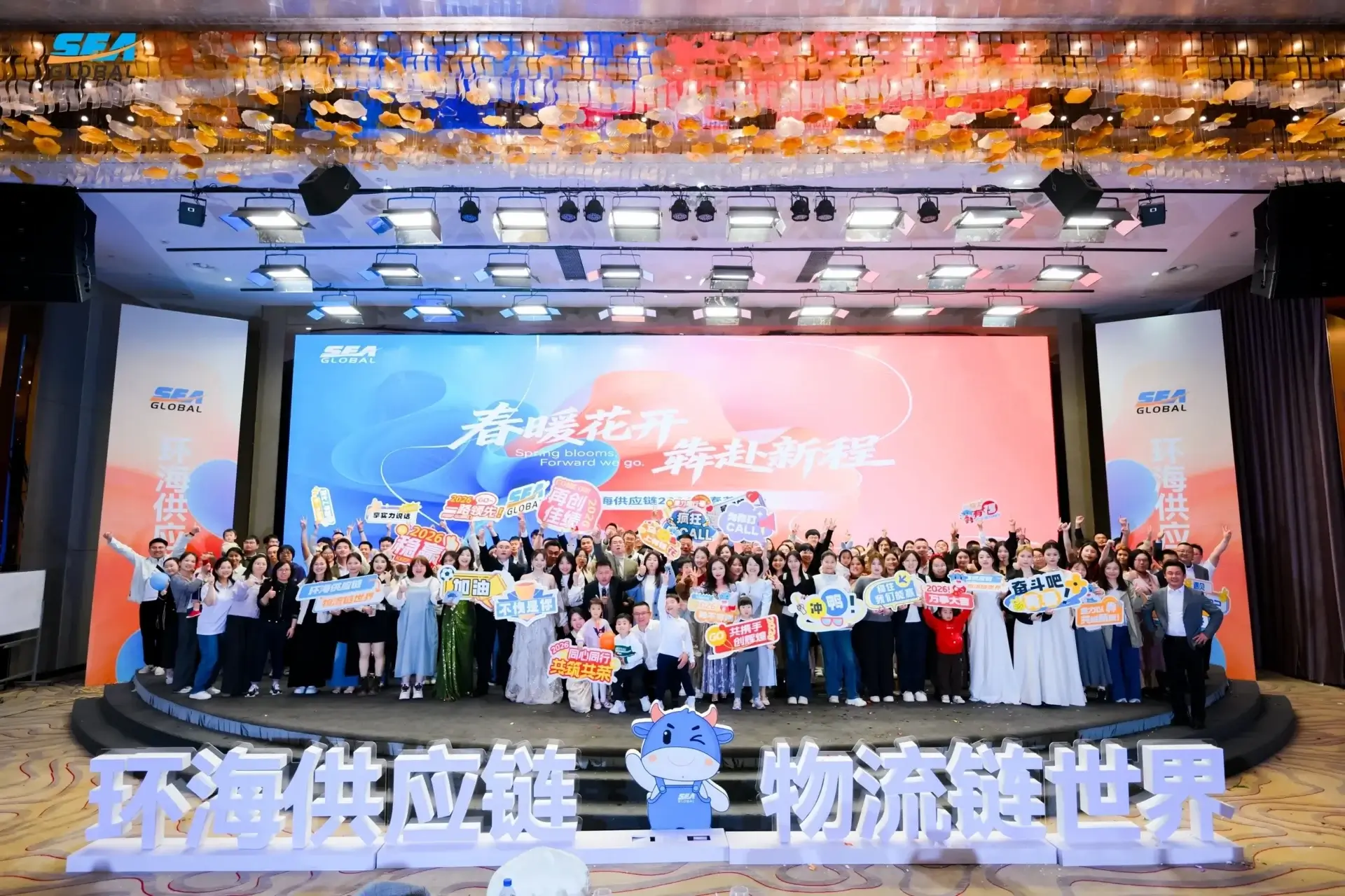 Group photo at a corporate event stage.